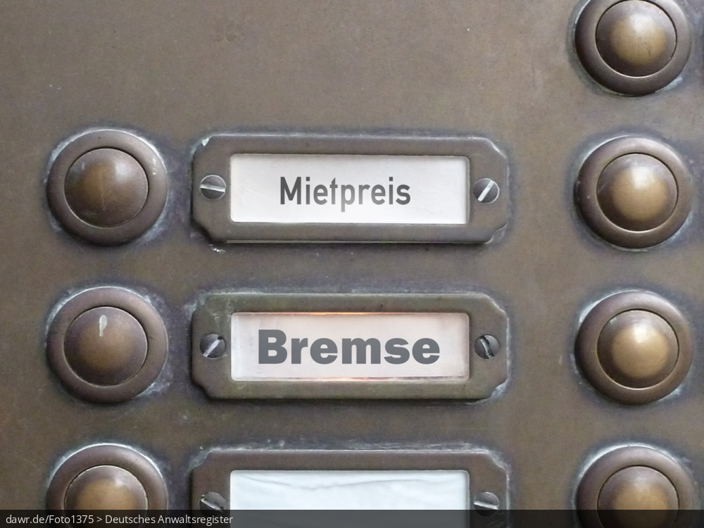 Dieses Foto zeigt einen Teil des Klingelschilds eines Altbau-Mehrfamilienhauses, wobei die Namen „Mietpreis“ und „Bremse“ zu lesen sind. Diese symbolische Darstellung eignet sich gut für alle Themen rund um die Mietpreisbremse und hohe Mietkosten für Wohnungen in Deutschland.